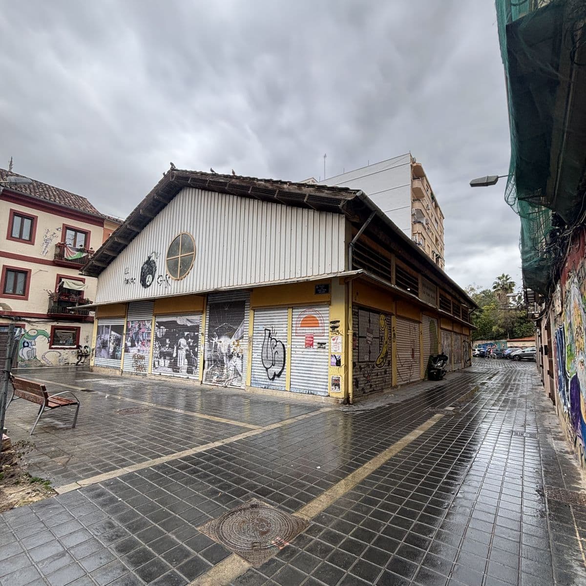 Le marché municipal de Sant Pere Nolasc à Morvedre, rideaux métalliques baissés et couverts de fresques, un jour de pluie