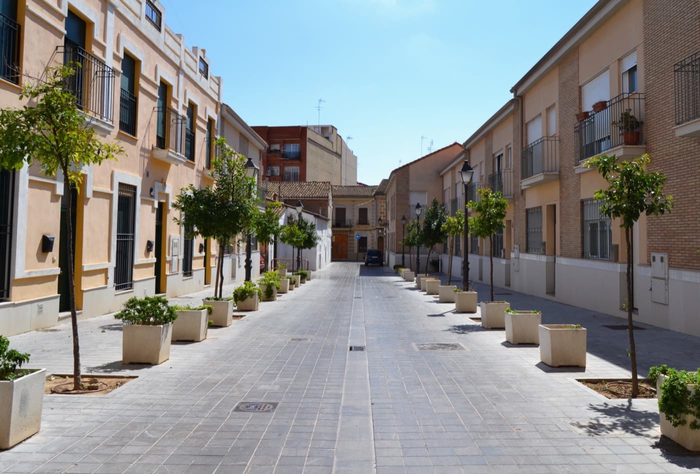 Rue piétonne du vieux Campanar, maisons basses à balcons et arbres en bacs (Valencia)