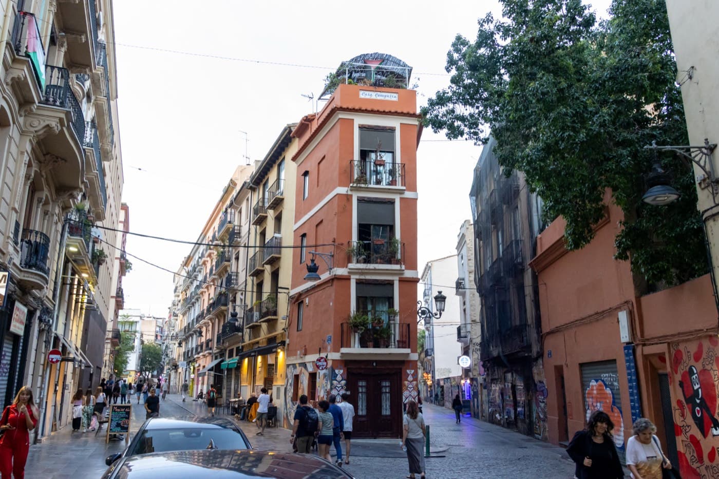 Rue animée d’El Carmen, immeuble étroit à l’angle et façades colorées (centre historique de Valencia)
