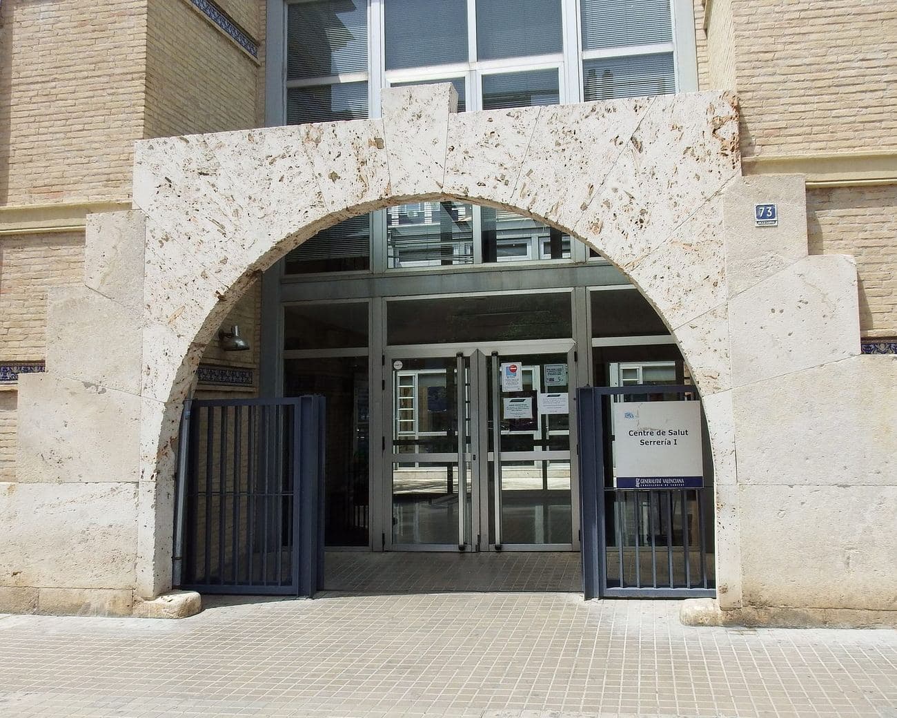 L’entrée en arc de pierre du Centre de Salut Serrería I, un centre de santé public de Valencia, avec son panneau de la Generalitat Valenciana