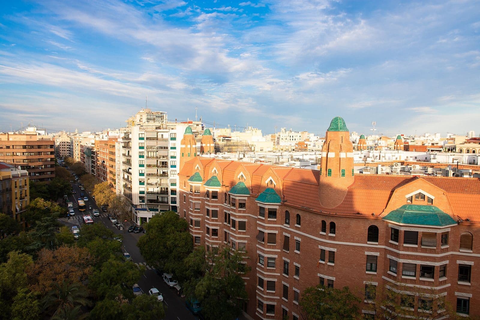 La Finca Roja, immeuble de logements en brique rouge à tourelles vertes achevé en 1933, et une rue arborée d’Arrancapins vue d’en haut (Valencia)