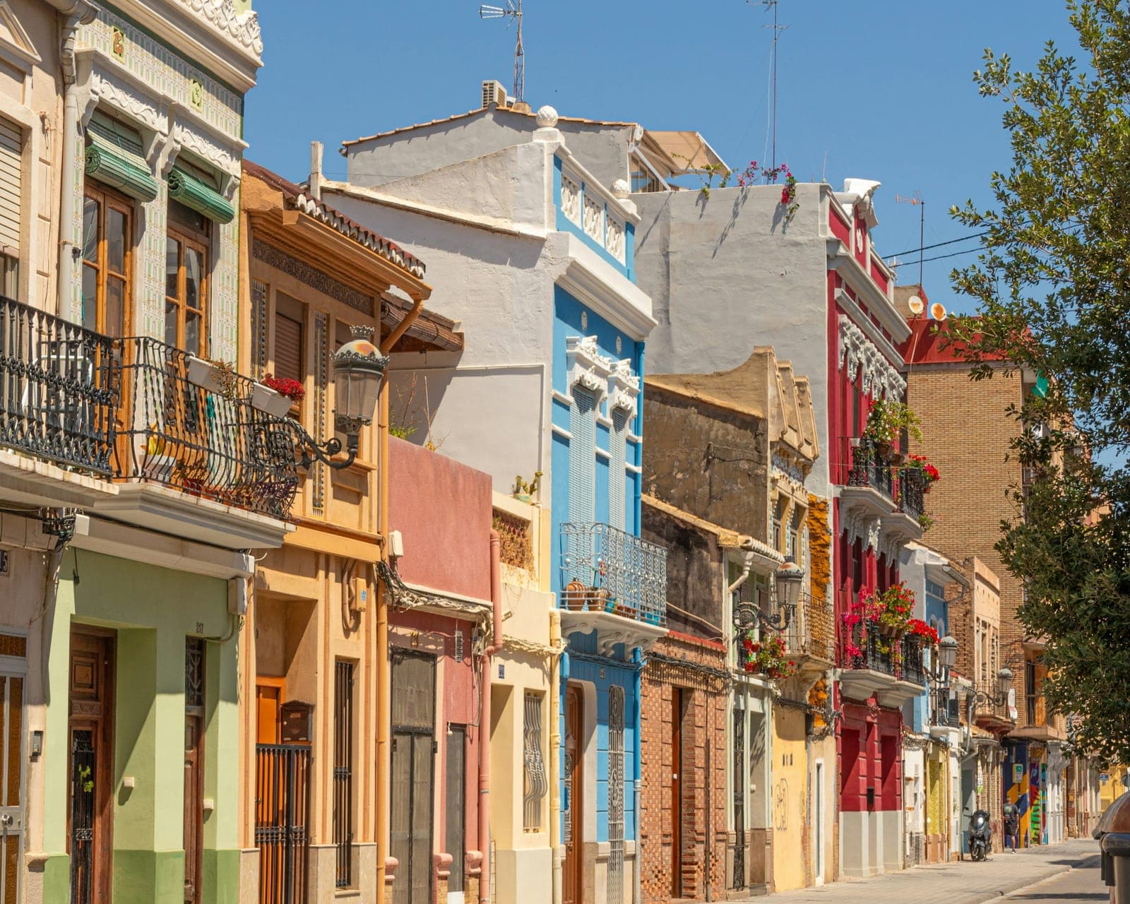 Maisons de ville aux façades colorées et balcons fleuris dans une rue du Cabanyal, à Valencia