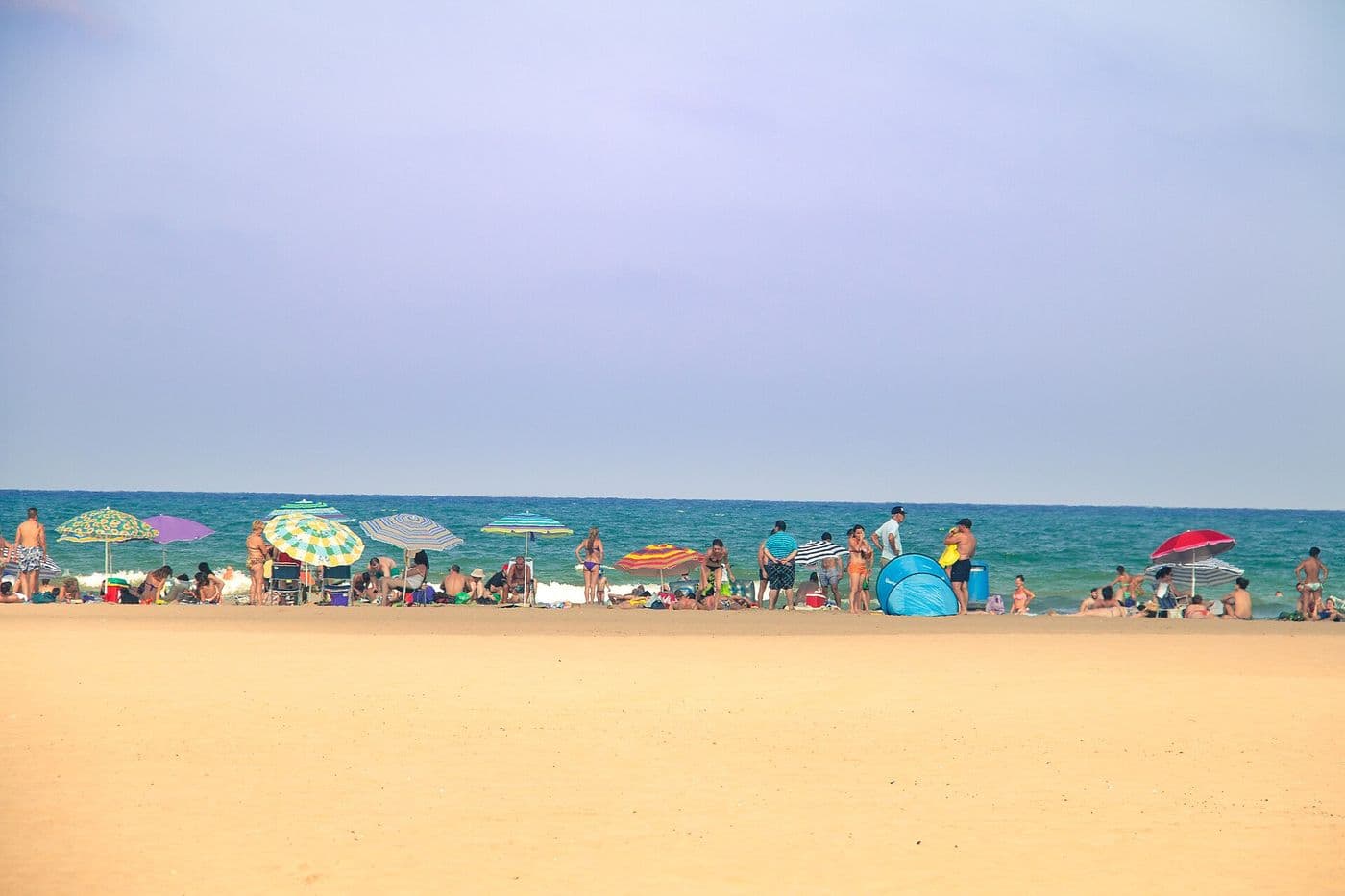 Baigneurs et parasols sur le sable de la plage de la Malvarrosa, à Valencia, un jour d’été